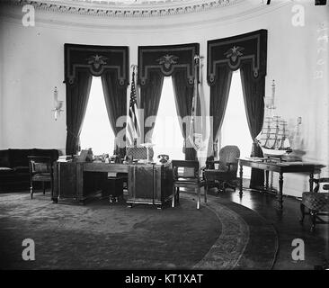 Das Bild zeigt Präsident Franklin D. Roosevelt im Jahr 1934 im Oval Office und hält einen bedeutenden Moment in der Geschichte der USA fest. Das Foto spiegelt Roosevelts Führung während der Großen Depression wider und zeigt das Präsidentenamt als Symbol für Macht und Einfluss während dieser schwierigen Periode der amerikanischen Geschichte. Stockfoto