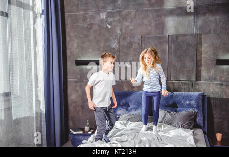 Geschwister, die springen auf Bett Stockfoto