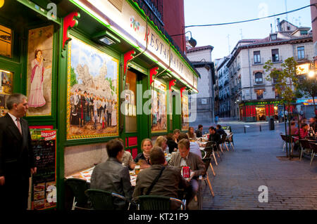 Menschen sitzen auf der Terrasse, bei Nacht. Nuntius Straße, Madrid, Spanien. Stockfoto