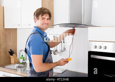 Handwerker Abzugshaube Filter prüfen. Stockfoto