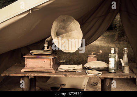 Camping Zelt mit einem alten Plattenspieler und verschiedene Objekte auf einem rustikalen Holztisch. Stockfoto