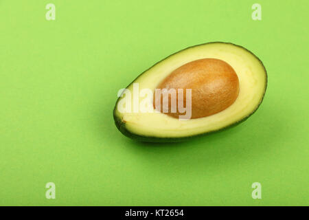 Frische reife Avocado auf grünem Papier Stockfoto