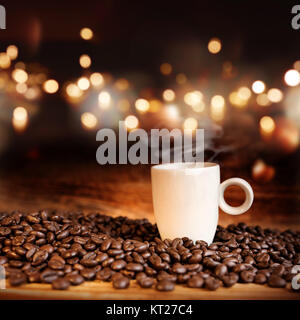 Noch immer leben mit einer dampfenden Tasse Espresso vor einem abstrakten Hintergrund mit Bokeh für eine Coffee house Konzept Stockfoto