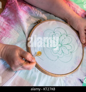 Künstler zeichnet die Kontur der Blume auf Batik Stockfoto