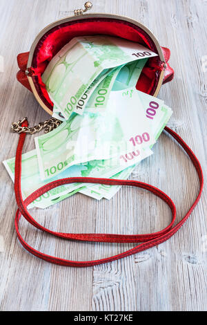 100 Euro Banknoten heraus fallen aus roten Handtasche Stockfoto