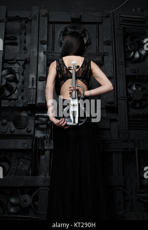 Eine Frau steht mit Violine zurück zu den Fotografen Stockfoto