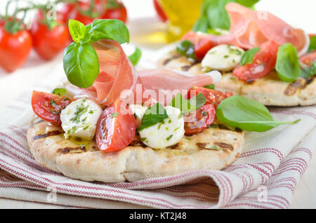 Pita Brot mit italienischer Schinken, Tomate, Mozzarella und Basilikum Stockfoto