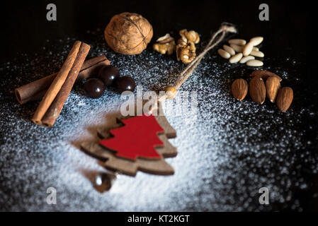 Weihnachtsdekoration und Walnüsse, Mandeln, Pinienkerne, Zimt, Schokolade Stockfoto