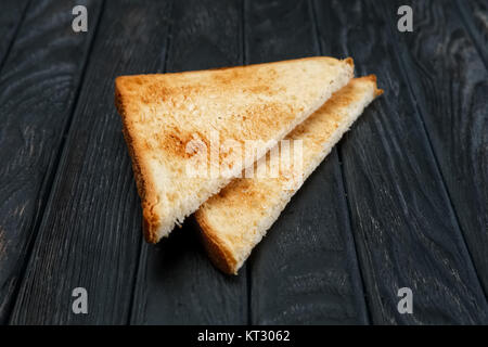 Zwei Scheiben Toast Brot auf dunklen Holztisch. Ansicht von oben. Stockfoto