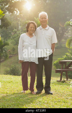 Asiatischer seniors Paar gehen mit outdoor Park Stockfoto