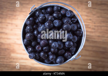 Heidelbeeren auf Holztisch Hintergrund. Reif und saftig frisch gepflückten Heidelbeeren Nahaufnahme. Beeren-Nahaufnahme Stockfoto