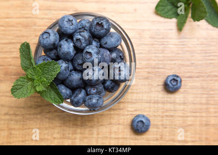 Heidelbeeren auf Holztisch Hintergrund. Reif und saftig frisch gepflückten Heidelbeeren Nahaufnahme. Beeren-Nahaufnahme Stockfoto