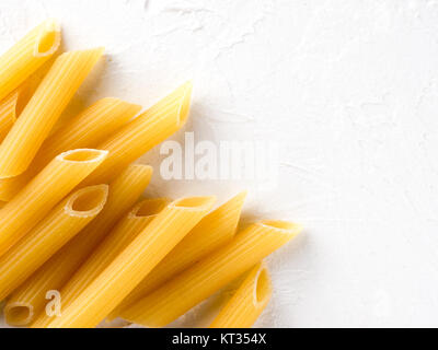 Rohe Nudeln Penne auf weißem Hintergrund Stockfoto