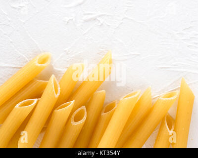 Rohe Nudeln Penne auf weißem Hintergrund Stockfoto