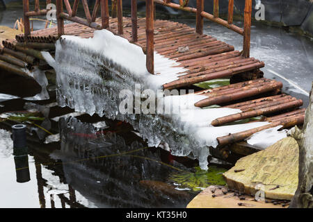 Eiszapfen hängen von einer Brücke Stockfoto