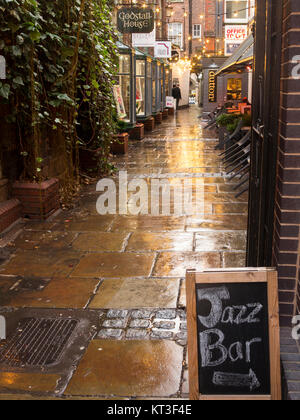 Blick entlang der nassen Fahrbahnen der mittelalterlichen godstall Lane verbindet das Stadtzentrum mit der Kathedrale in der römischen Stadt Chester Cheshire England Stockfoto