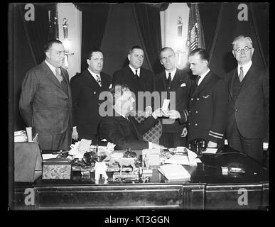 Ein Schwarzweiß-Foto aus dem Jahr 1933, auf dem Präsident Franklin D. Roosevelt am Hoover-Schreibtisch im Oval Office saß und den damaligen Präsidentenarbeitsraum reflektiert. Stockfoto