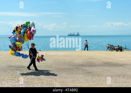 Frau mit bunten Luftballons für Verkauf zu Fuß entlang der Küste von Thessaloniki, Thessaloniki, Griechenland Stockfoto