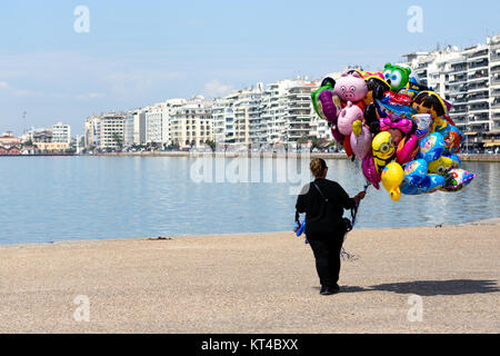 Frau mit bunten Luftballons für Verkauf zu Fuß entlang der Küste von Thessaloniki, Griechenland Stockfoto