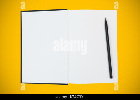Buch mit leeren weißen Seiten und schwarzem Holz Bleistift auf gelben Hintergrund öffnen Stockfoto