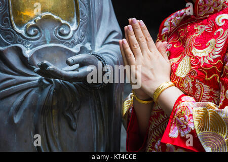 Frau Hand in Bezug auf Buddha-Statue. Stockfoto