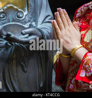 Frau Hand in Bezug auf Buddha-Statue. Stockfoto