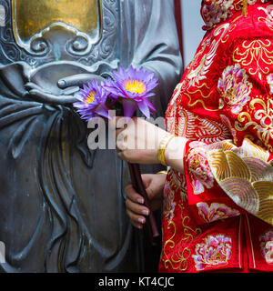 Frau Hand in Bezug auf Buddha-Statue. Stockfoto