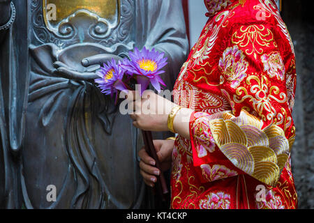 Frau Hand in Bezug auf Buddha-Statue. Stockfoto