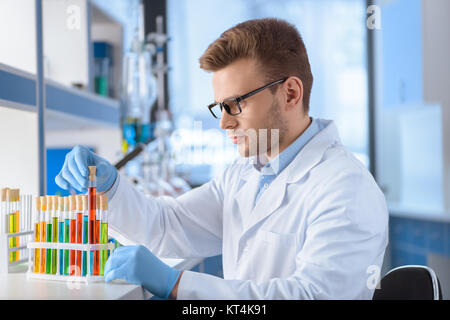 Konzentrierte sich Wissenschaftler in Brillen arbeiten mit den Reagenzgläsern in Lab Stockfoto