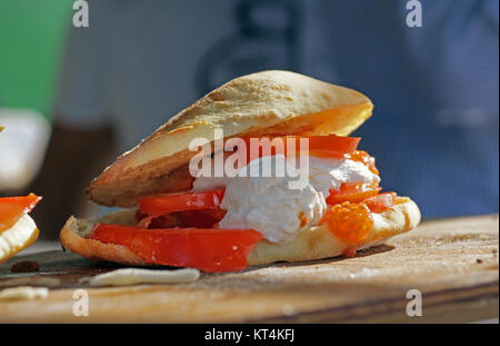 Sandwich ergreifen. Hamburger mit Schweinefleisch, Rindfleisch und Gemüse ist im Brot Stockfoto