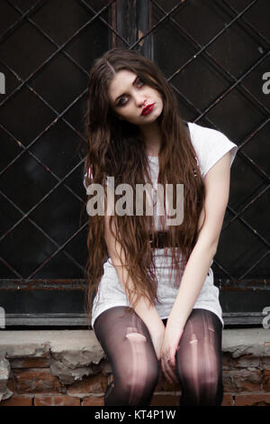 Schöne Goth Girl. Horror Frau. Scary Girl und Halloween Thema: porträt einer verrückten Mädchen mit einem blutigen Gesicht im Studio. Ghost Mädchen, grauen Hintergrund für Halloween Konzept und Buch Cover Ideen. Stockfoto