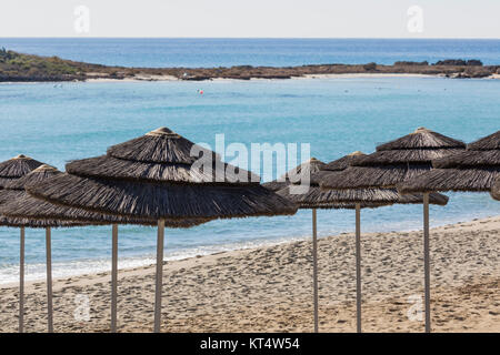 Detail der geflochtenen Sonnenschirme über Reihen am Strand in Zypern. Stockfoto