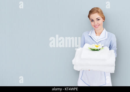 Zimmermädchen Holding Stapel Handtücher Stockfoto