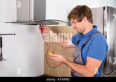 Handwerker Abzugshaube Filter prüfen. Stockfoto