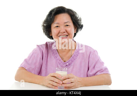 Ältere Erwachsene Frau trinkt Milch Stockfoto