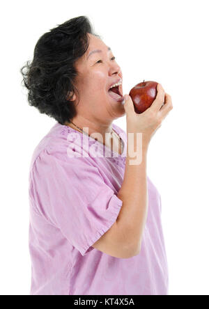 Asiatische älteren Erwachsenen Frau essen Apple Stockfoto
