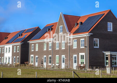 Moderne Reihenhäuser mit Solarzellen, braunen Backsteinen und roten Dachziegeln im neoklassischen Stil in Groningen Niederlande an einem sonnigen Tag Stockfoto