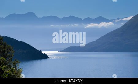 Blick auf die Remarkables über den Lake Wakatipu nahe Queenstown, Neuseeland in blauen Dunst am frühen Morgen Stockfoto