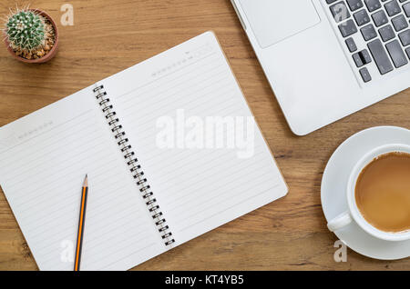 Schreibtisch aus Holz Tisch mit Notebook, Computer, Laptop, Bleistift, Kakteen und Tasse Kaffee. Ansicht von oben mit der Kopie. Stockfoto