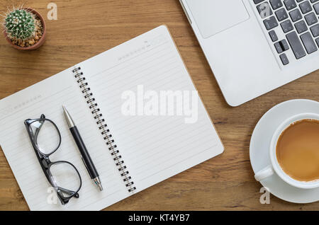 Schreibtisch aus Holz Tisch mit Notebook, Computer, Laptop, Stift, Brille, Kakteen und Tasse Kaffee. Ansicht von oben mit der Kopie Raum Stockfoto