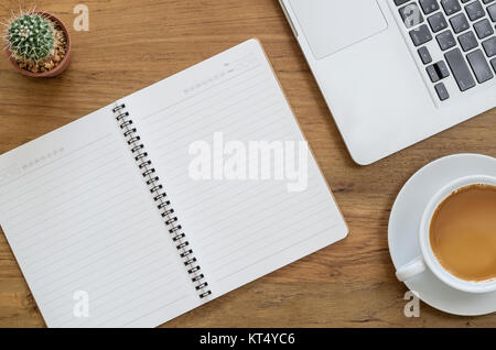 Schreibtisch aus Holz Tisch mit Notebook, Computer, Laptop, Kakteen und Tasse Kaffee. Ansicht von oben mit der Kopie. Stockfoto