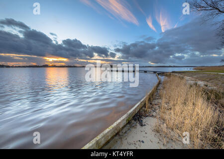 Sonnenuntergang über Camp shedding am Ufer des Sees Paterswoldsemeer in den Niederlanden Stockfoto