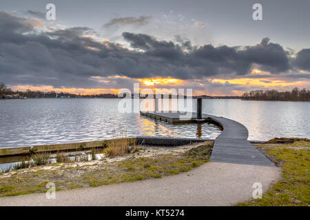 Die schwimmende Hafenmole bei Sonnenuntergang am Ufer des Sees Paterswoldsemeer in den Niederlanden Stockfoto