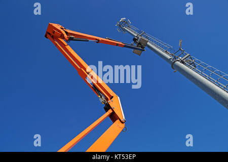 Hydraulische mobile Konstruktion Plattform erhöht auf dem Weg zu einer blauen Himmel mit Metallmast mit street lamp Stockfoto