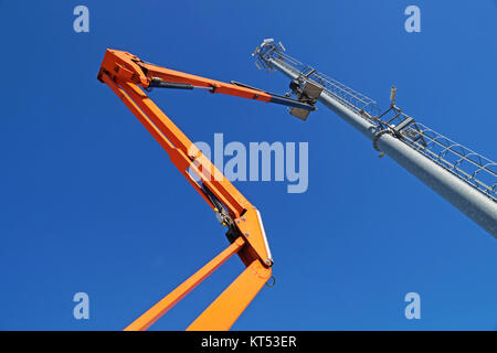 Hydraulische mobile Konstruktion Plattform erhöht auf dem Weg zu einer blauen Himmel mit Metallmast mit street lamp Stockfoto