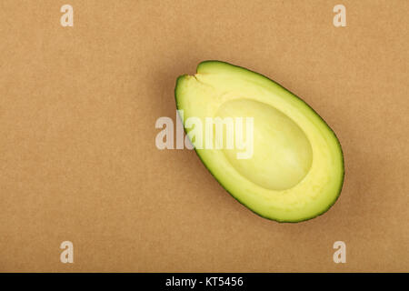 Frische reife Avocado grün auf braunem Papier Pergament Stockfoto