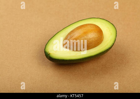 Frische reife Avocado grün auf braunem Papier Pergament Stockfoto