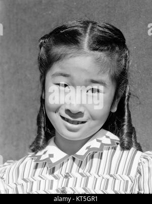 Dieses ikonische Foto von Ansel Adams zeigt Joyce Yuki Nakamura, eine japanische Amerikanerin, im Internierungslager Manzanar während des Zweiten Weltkriegs. Das Porträt zeigt die menschliche Widerstandsfähigkeit unter den Ungerechtigkeiten der harten Bedingungen des Lagers. Stockfoto