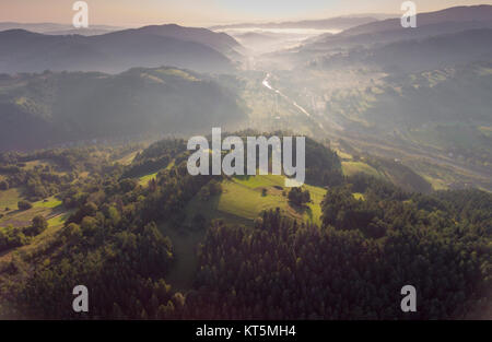 Landschaft misty Panorama. Fantastische verträumte Sonnenaufgang auf Rocky Mountains mit Blick in nebligen Tal. Foggy Forest Hills. Blick von oben. Ochotnica Dolna Dorf, Polen. Stockfoto