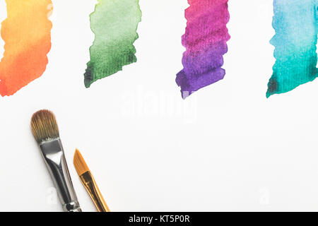 Nahaufnahme der Pinsel und bunten hellen Pinselstriche isoliert auf weißem Stockfoto